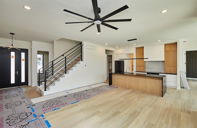 4727 Hillsdale Dr, Urbandale, IA 50322 - kitchen featuring ceiling fan, dark countertops, light wood finished floors, open floor plan, and recessed lighting