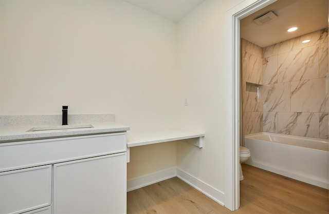 4727 Hillsdale Dr, Urbandale, IA 50322 - full bathroom featuring wood finished floors, toilet, vanity, baseboards, and shower / bathtub combination