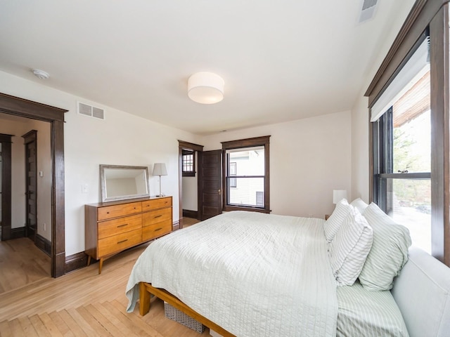 bedroom featuring light wood finished floors and baseboards
