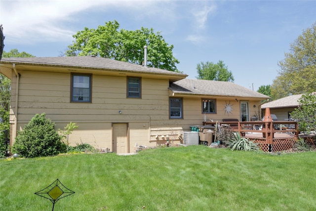 rear view of property with a wooden deck and a yard