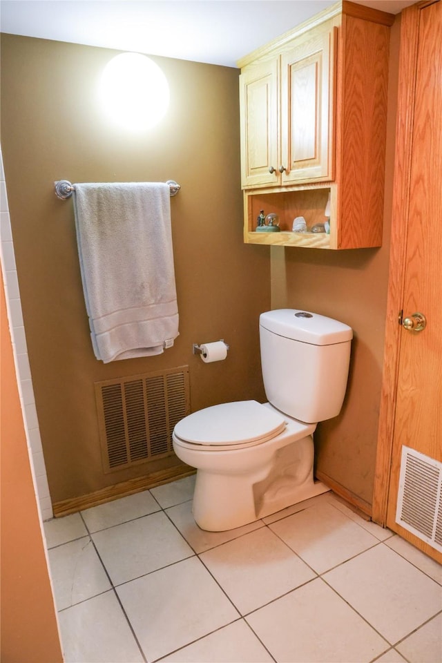 bathroom with toilet, tile patterned floors, and baseboards