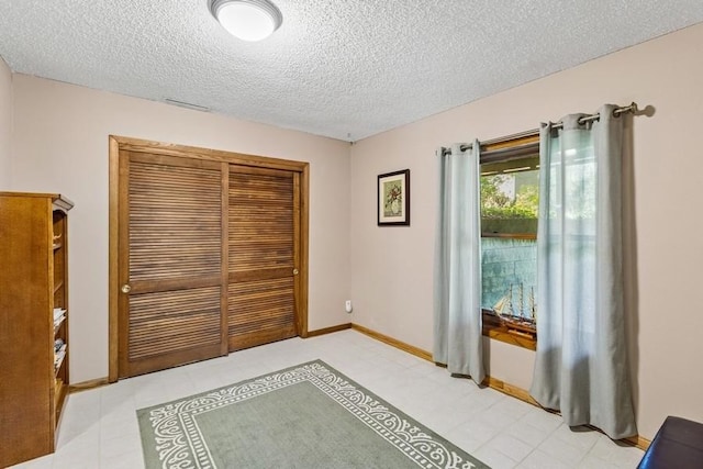 3919 Burr Oak Ln, Ames, IA 50014 - bedroom with a textured ceiling, a closet, and baseboards