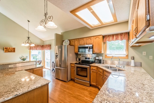 1249 NW 108th Cir, Clive, IA 50325 - kitchen featuring appliances with stainless steel finishes, a sink, plenty of natural light, a chandelier, and high vaulted ceiling