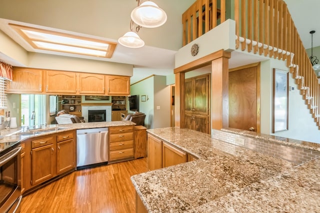 1249 NW 108th Cir, Clive, IA 50325 - kitchen featuring stainless steel appliances, light wood-type flooring, a fireplace, a sink, and decorative backsplash