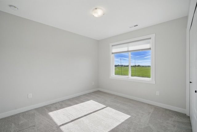 empty room with light colored carpet, a smoke detector, and baseboards