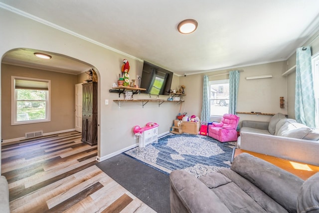 1523 Allison Ave, Des Moines, IA 50314 - living room with arched walkways, wood finished floors, plenty of natural light, ornamental molding, and baseboards