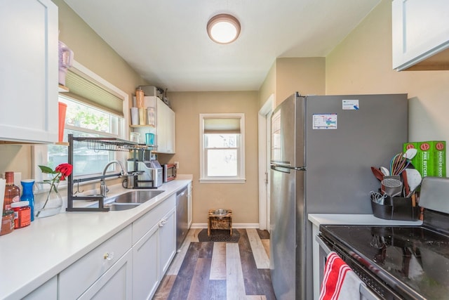 1523 Allison Ave, Des Moines, IA 50314 - kitchen with stainless steel appliances, a sink, dark wood-style floors, and white cabinetry