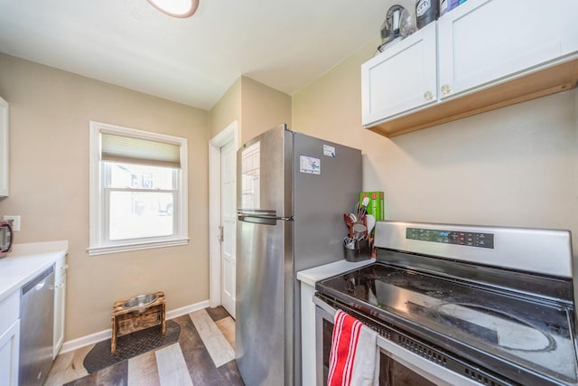 1523 Allison Ave, Des Moines, IA 50314 - kitchen with stainless steel appliances, light countertops, white cabinets, light wood-type flooring, and baseboards