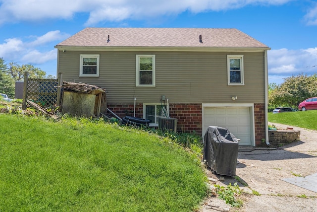 1523 Allison Ave, Des Moines, IA 50314 - back of property featuring a garage, cooling unit, driveway, and brick siding