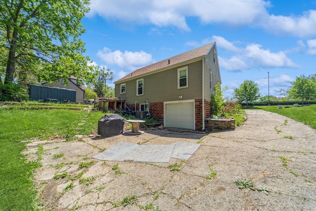 1523 Allison Ave, Des Moines, IA 50314 - rear view of house featuring brick siding, driveway, and a garage