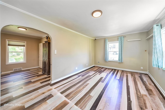 1523 Allison Ave, Des Moines, IA 50314 - unfurnished room featuring arched walkways, wood finished floors, crown molding, and baseboards