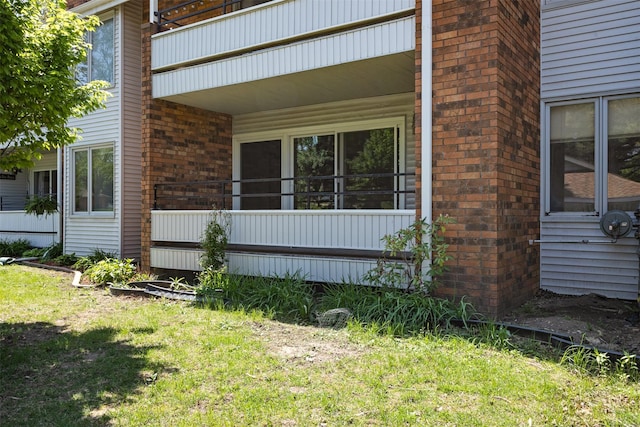 view of property exterior featuring brick siding and a lawn