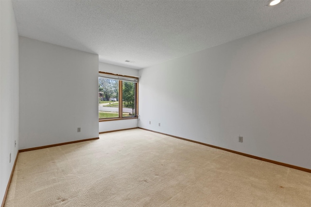 unfurnished room featuring light colored carpet, a textured ceiling, recessed lighting, and baseboards