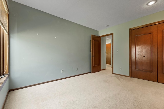 unfurnished bedroom with light carpet and baseboards