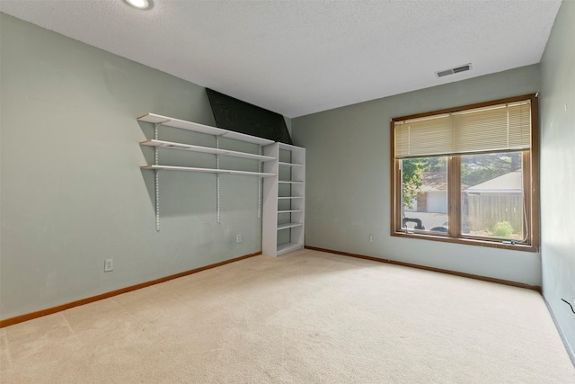 unfurnished bedroom featuring carpet flooring, a textured ceiling, and baseboards
