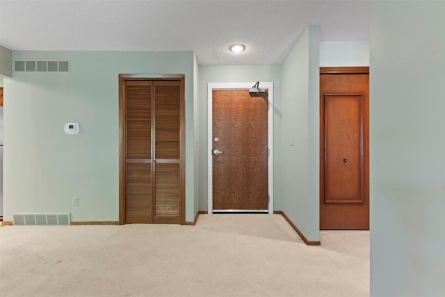unfurnished bedroom featuring carpet, baseboards, and a textured ceiling