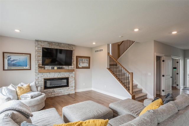 2920 Oak St, Norwalk, IA 50211 - living room featuring wood finished floors, stairs, a stone fireplace, baseboards, and recessed lighting