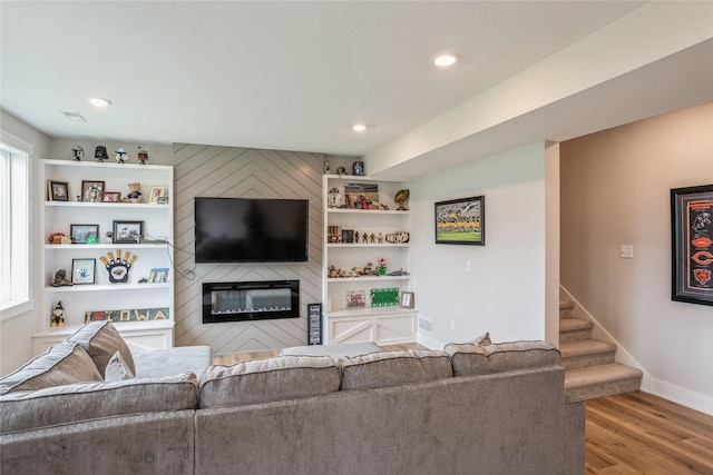 2920 Oak St, Norwalk, IA 50211 - living room featuring wood finished floors, a large fireplace, baseboards, stairway, and built in shelves