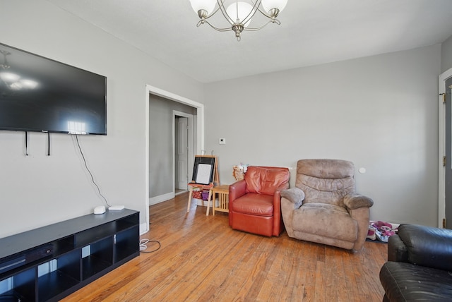 2057 Maple St, Des Moines, IA 50317 - living area featuring a chandelier, light wood-style flooring, and baseboards