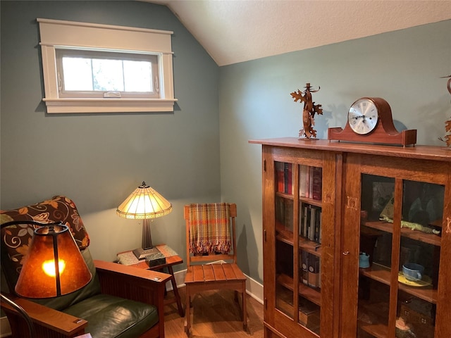 sitting room with wood finished floors and vaulted ceiling