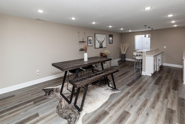 dining area featuring baseboards, wood finished floors, and recessed lighting