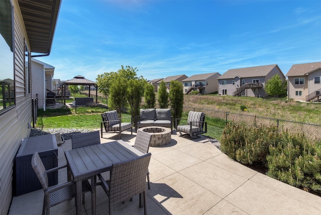 view of patio / terrace with a gazebo, a residential view, and an outdoor living space with a fire pit