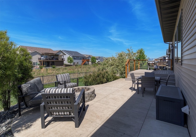 view of patio / terrace with outdoor dining area, an outdoor living space with a fire pit, and a residential view