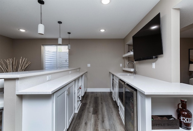 kitchen featuring open shelves, a sink, a peninsula, beverage cooler, and light countertops