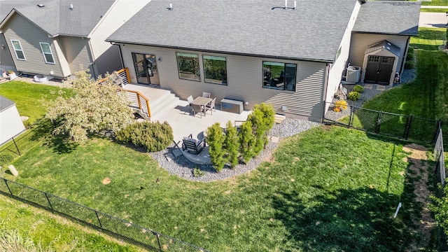 rear view of property featuring a patio area, a shed, roof with shingles, an outdoor structure, and central air condition unit