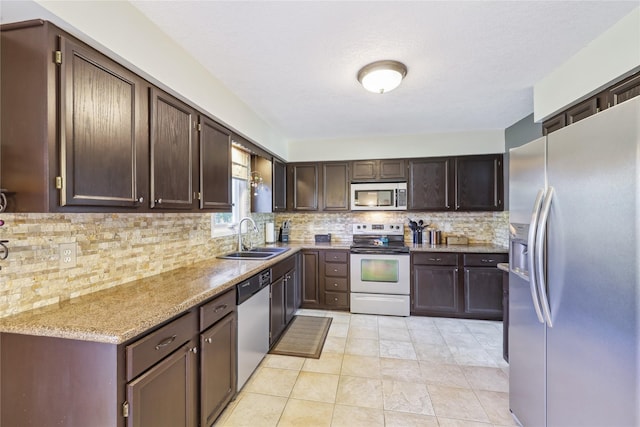 4727 80th Pl, Urbandale, IA 50322 - kitchen with stainless steel appliances, tasteful backsplash, light stone countertops, and dark brown cabinetry