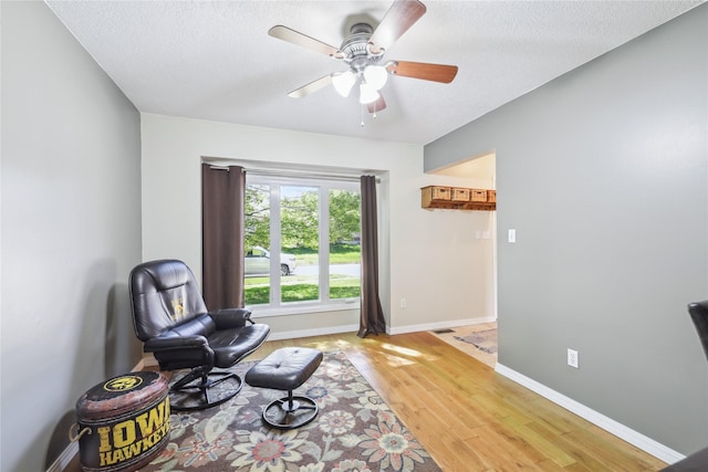 4727 80th Pl, Urbandale, IA 50322 - living area featuring light wood finished floors, ceiling fan, and a textured ceiling