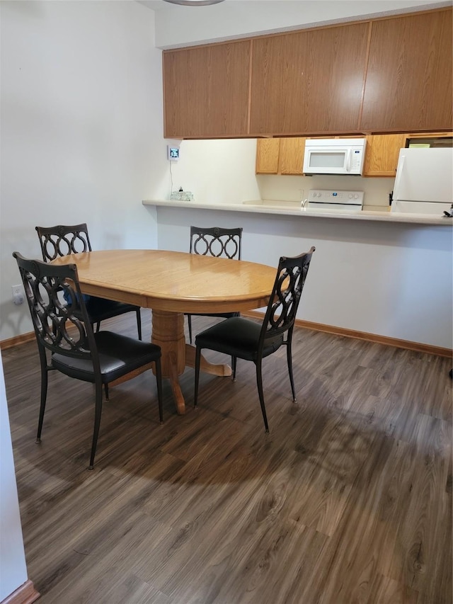 1210 NE 6th Ln Unit I9, Ankeny, IA 50021 - dining area featuring dark wood-style floors and baseboards