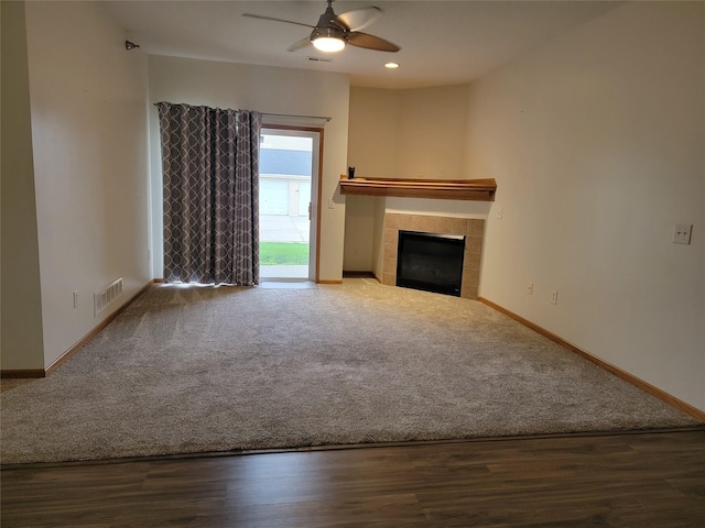 1210 NE 6th Ln Unit I9, Ankeny, IA 50021 - unfurnished living room featuring a fireplace, a ceiling fan, carpet floors, and wood finished floors