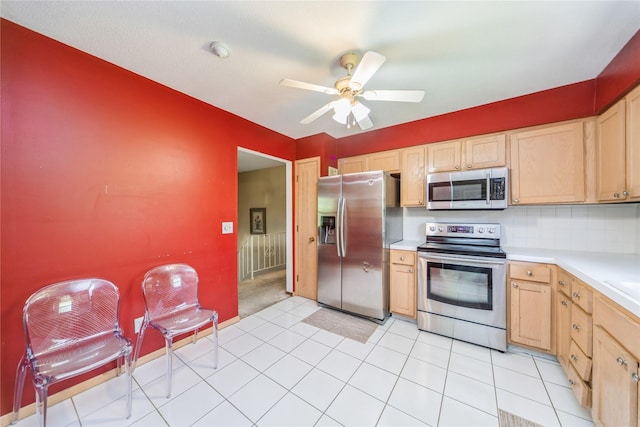 4021 80th St, Urbandale, IA 50322 - kitchen with appliances with stainless steel finishes, light countertops, light brown cabinets, a ceiling fan, and decorative backsplash