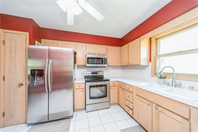 4021 80th St, Urbandale, IA 50322 - kitchen featuring stainless steel appliances, light brown cabinets, light countertops, a sink, and light tile patterned floors