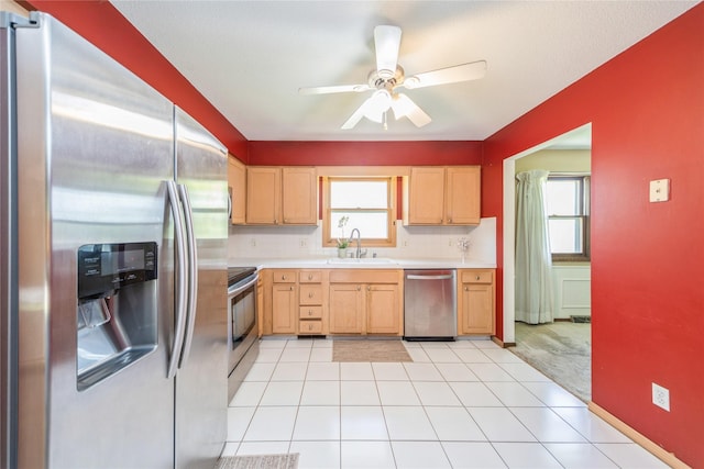 4021 80th St, Urbandale, IA 50322 - kitchen featuring stainless steel appliances, light countertops, a sink, light brown cabinetry, and ceiling fan
