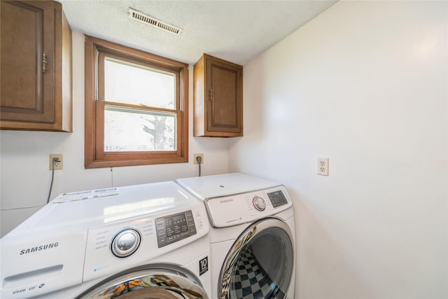 4021 80th St, Urbandale, IA 50322 - washroom featuring cabinet space, washing machine and dryer, and a textured ceiling