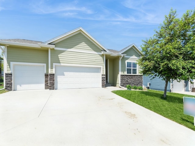 view of front of home with stone siding, a garage, driveway, and a front yard