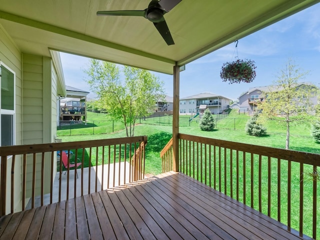 wooden terrace with ceiling fan, a residential view, and a playground
