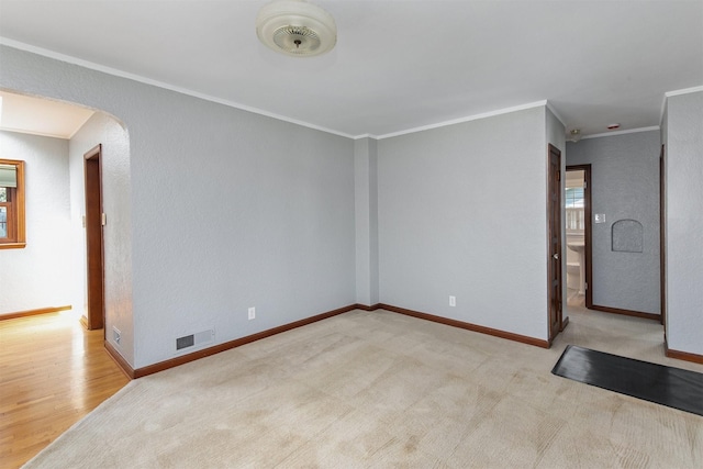 2400 39th St, Des Moines, IA 50310 - empty room with arched walkways, crown molding, baseboards, and wood finished floors
