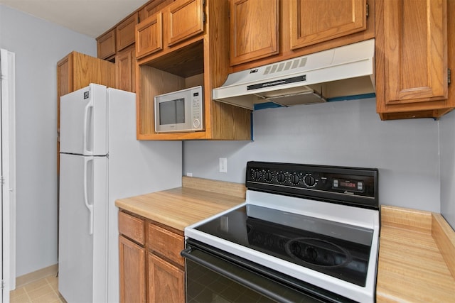 2400 39th St, Des Moines, IA 50310 - kitchen with white appliances, under cabinet range hood, and brown cabinetry