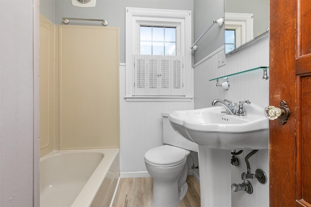 2400 39th St, Des Moines, IA 50310 - full bathroom with wainscoting, toilet, wood finished floors, and baseboards