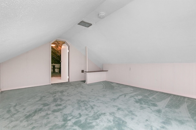 2400 39th St, Des Moines, IA 50310 - additional living space with lofted ceiling, carpet floors, and a textured ceiling