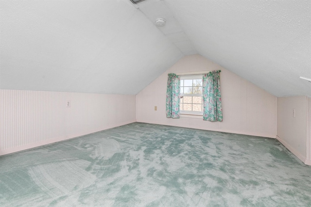 2400 39th St, Des Moines, IA 50310 - bonus room with carpet flooring, vaulted ceiling, a textured ceiling, and baseboards