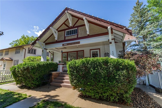 view of front facade featuring covered porch and fence