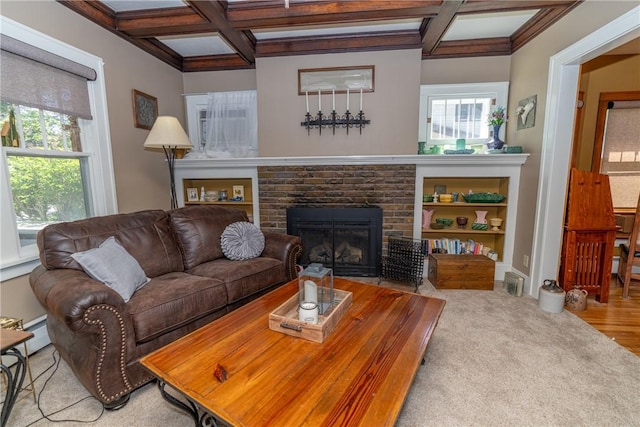 carpeted living room with coffered ceiling, beamed ceiling, a brick fireplace, and a baseboard heating unit