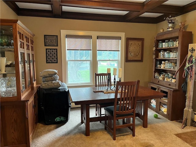 dining room featuring coffered ceiling, beamed ceiling, and light colored carpet