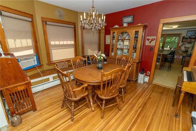 dining room with a chandelier, wood finished floors, and cooling unit