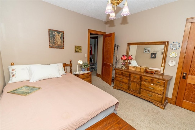 carpeted bedroom with a chandelier and baseboards