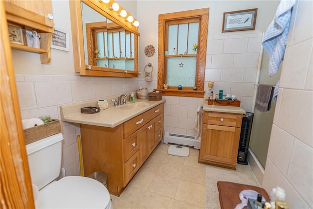 full bath with tile walls, a baseboard radiator, toilet, tile patterned flooring, and vanity